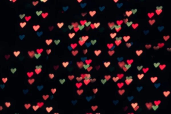 Bokeh glitter and colorful heart shape on black background, — Stock Photo, Image