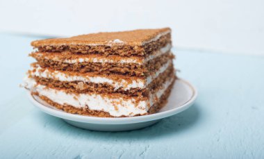 Plaka, mavi ahşap arka plan üzerinde kum pastadan bir parça,