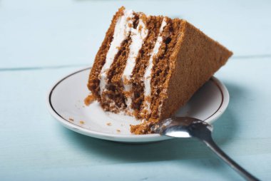 Plaka, mavi ahşap arka plan üzerinde kum pastadan bir parça,