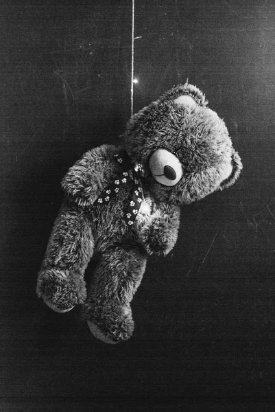 Teddybär wurde an einer Girlande aufgehängt, das Konzept des Selbstmordes, ein dramatischer Effekt und digitales Rauschen, — Stockfoto