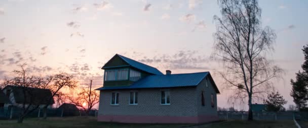Кирпичный дом с мансардой на закате, весенний закат , — стоковое видео