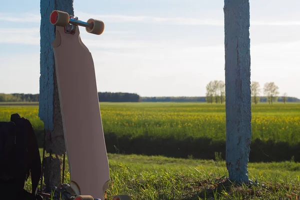 Longboard outdoor, langs de weg pole op de achtergrond van de groene weide, — Stockfoto