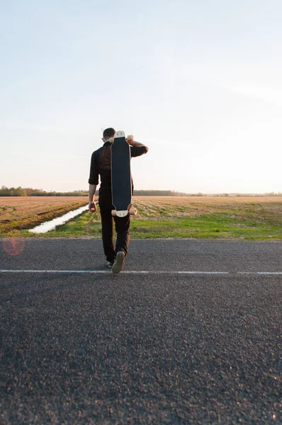 Killen med longboard är på asfalt, — Stockfoto
