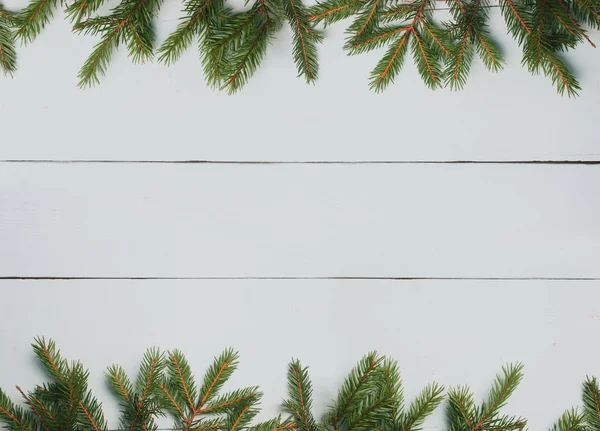 Mesa de madeira branca e ramos de abeto. Fundo de Natal — Fotografia de Stock