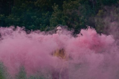 Pembe duman tarafından çevrili kız