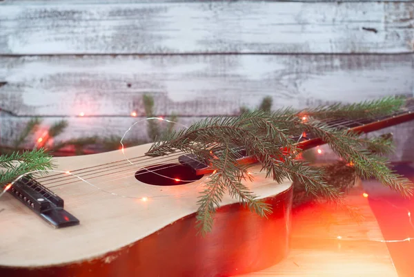 Акустическая гитара с гирляндой и елкой на деревянном фоне, рождественский подарок , — стоковое фото