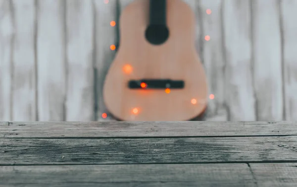 Tavolo in legno vuoto con sfondo musicale sfocato. banner per chitarra pubblicitaria , — Foto Stock