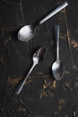 çay kaşıkları koyu beton üzerinde uzanır.,
