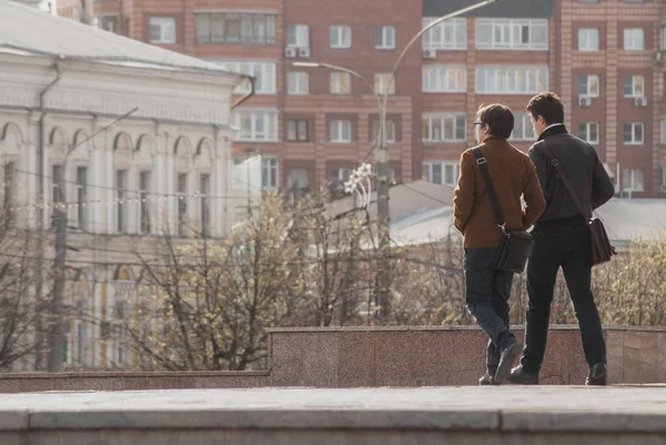 两个年轻人正在从工作中走回来 两个男人在城中走着 — 图库照片