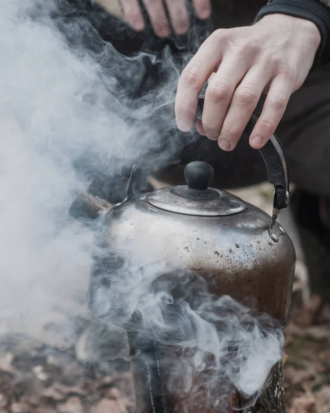 Stará konvice nad ohněm. Muž vaří vodu na čaj, když cestuje, — Stock fotografie