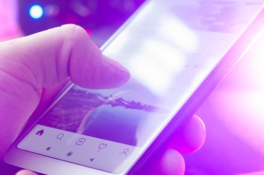 BELARUS, MARCH 15, 2020: hand flips instagram feed close-up, social media addiction,