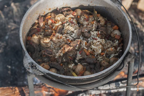 Pilaf with mushrooms in a cauldron cooked over a fire, — Stock Image Pilaf with mushrooms in a cauldron cooked over a fire, Stock Picture