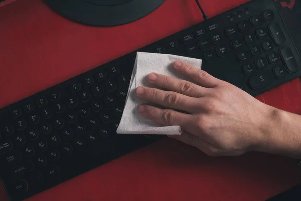 Uma mão de homem limpa o teclado com uma vista superior de guardanapo — Fotografia de Stock