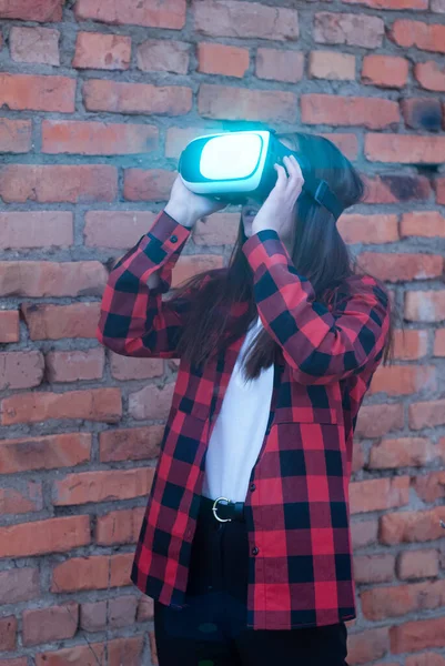 The girl in the red shirt watching a video in VR glasses