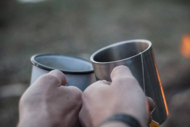 Kamp ateşinin arka planında iki turist çemberi, yakın plan, doğada dinlenme,