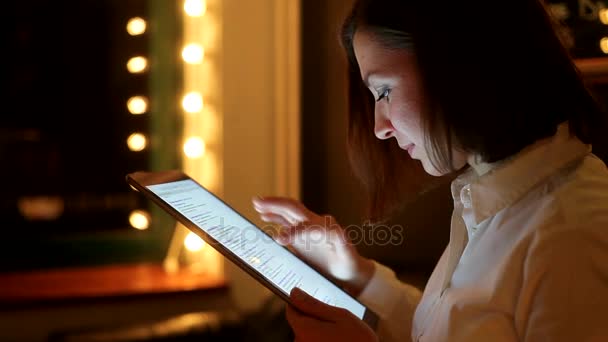 Primer plano de una mujer sonriendo en su tableta digital en un café — Vídeo de stock