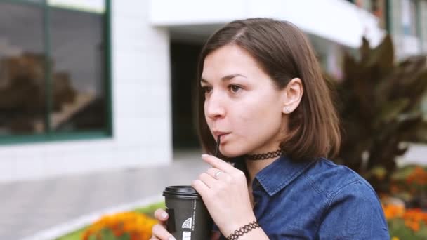 Chica bebiendo té de café caliente en la taza de comida para llevar fuera — Vídeo de stock