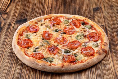 Çok sıcak ve baharatlı pizza, jalapeno, pepperoni ve ahşap zemin üzerinde kırmızı soğan.
