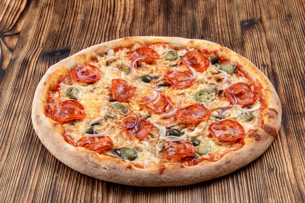 Çok sıcak ve baharatlı pizza, jalapeno, pepperoni ve ahşap zemin üzerinde kırmızı soğan.