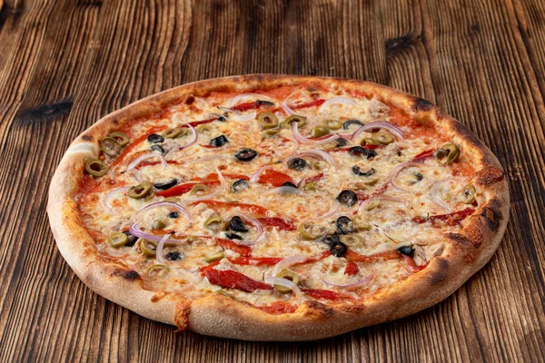 Ιταλική πίτσα με κόκκινο κρεμμύδι, μαύρες και πράσινες ελιές, λιωμένο τυρί και κέτσαπ σε ρουστίκ υφή φόντο — Φωτογραφία Αρχείου