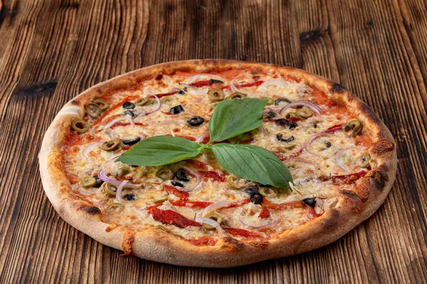 Ιταλική πίτσα με κόκκινο κρεμμύδι, μαύρες και πράσινες ελιές, λιωμένο τυρί και κέτσαπ σε ρουστίκ υφή φόντο — Φωτογραφία Αρχείου