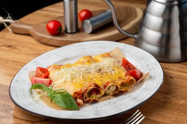Hindi ve sebzelerle doldurulmuş Cannelloni, erimiş çedar peyniri ve mozzarella peyniri.