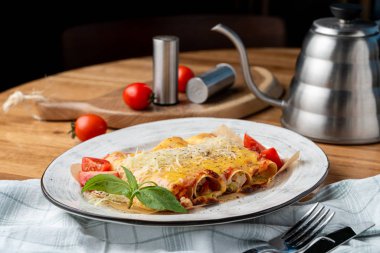 Hindi ve sebzelerle doldurulmuş Cannelloni, erimiş çedar peyniri ve mozzarella peyniri.