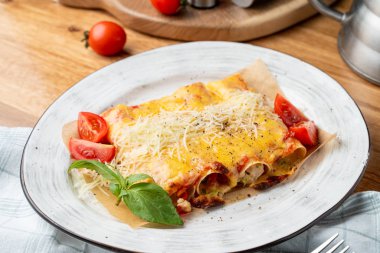 Hindi ve sebzelerle doldurulmuş Cannelloni, erimiş çedar peyniri ve mozzarella peyniri.