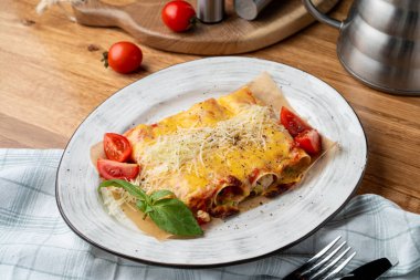 Hindi ve sebzelerle doldurulmuş Cannelloni, erimiş çedar peyniri ve mozzarella peyniri.