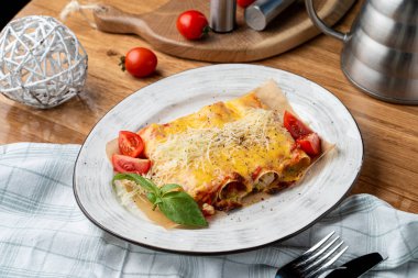Hindi ve sebzelerle doldurulmuş Cannelloni, erimiş çedar peyniri ve mozzarella peyniri.