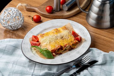 Hindi ve sebzelerle doldurulmuş Cannelloni, erimiş çedar peyniri ve mozzarella peyniri.