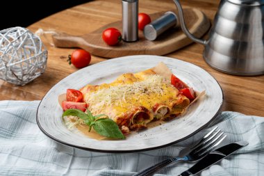 Hindi ve sebzelerle doldurulmuş Cannelloni, erimiş çedar peyniri ve mozzarella peyniri.