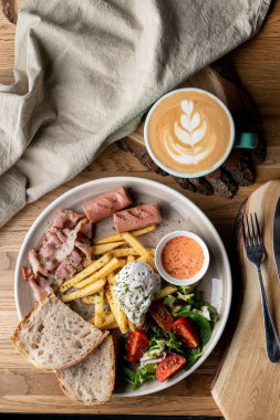 Pastırmalı, kavrulmuş sosisli, haşlanmış yumurta ve salatalı bir kafede önemli bir kahvaltı.