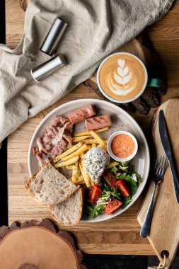 Pastırmalı, kavrulmuş sosisli, haşlanmış yumurta ve salatalı bir kafede önemli bir kahvaltı.