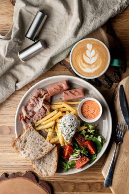 Pastırmalı, kavrulmuş sosisli, haşlanmış yumurta ve salatalı bir kafede önemli bir kahvaltı.