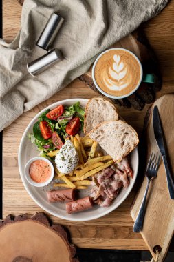Pastırmalı, kavrulmuş sosisli, haşlanmış yumurta ve salatalı bir kafede önemli bir kahvaltı.