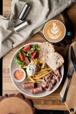 Pastırmalı, kavrulmuş sosisli, haşlanmış yumurta ve salatalı bir kafede önemli bir kahvaltı.