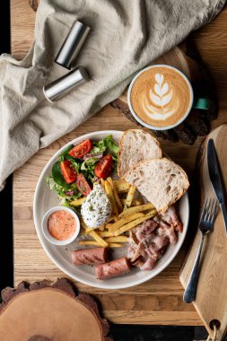 Pastırmalı, kavrulmuş sosisli, haşlanmış yumurta ve salatalı bir kafede önemli bir kahvaltı.