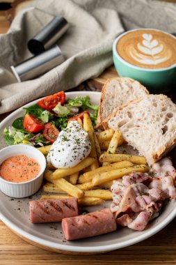 Pastırmalı, kavrulmuş sosisli, haşlanmış yumurta ve salatalı kahvaltıyı kapat.