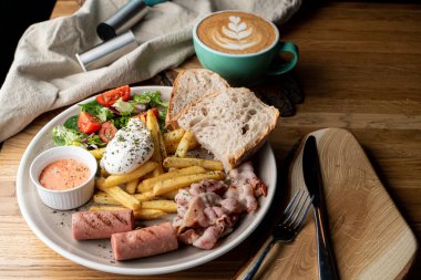 Pastırmalı, kavrulmuş sosisli, haşlanmış yumurta ve salatalı bir kafede önemli bir kahvaltı.