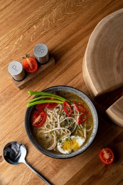 Tavuklu şehriye çorbası, haşlanmış yumurta, domates ve ahşap masada kırmızı biber.