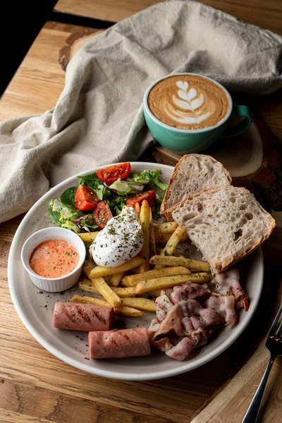 Pastırmalı, kavrulmuş sosisli, haşlanmış yumurta ve salatalı bir kafede önemli bir kahvaltı.