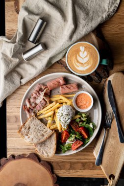 Pastırmalı, kavrulmuş sosisli, haşlanmış yumurta ve salatalı bir kafede önemli bir kahvaltı.