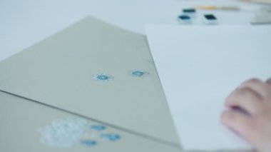 Young woman, a jewelry designer is drawing a sketch for a new ring at a jewelry production