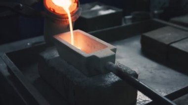 Hot and liquid precious metal is poured in a mold on a jewelry production