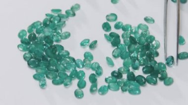 An expert selects diamonds and gems with tweezers on a jewelry production, close up macro shot