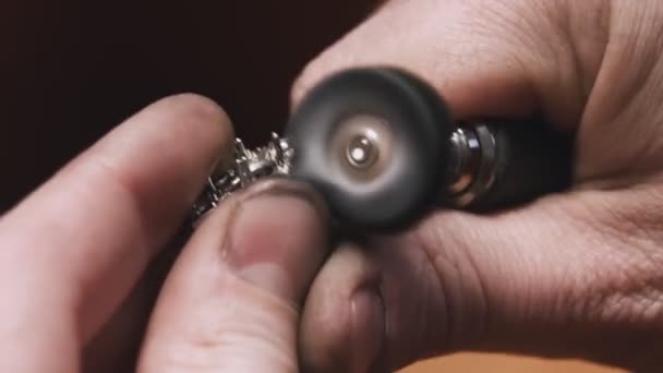 Production of rings. Jeweler working with with a blank of golden ring, grinding and polishing it with a special tool. Detailed shot with hands close up — 图库视频影像