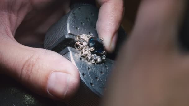 Production of rings. Jeweler working with with a blank of golden ring, grinding and polishing it with a special tool. Detailed shot with hands close up — 图库视频影像