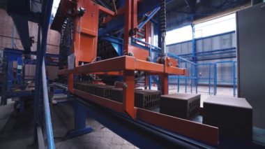 Gri tuğlalar tam otomatik fabrikanın üretim hattında ilerliyor.