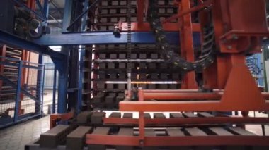 Gri tuğlalar tam otomatik fabrikanın üretim hattında ilerliyor.